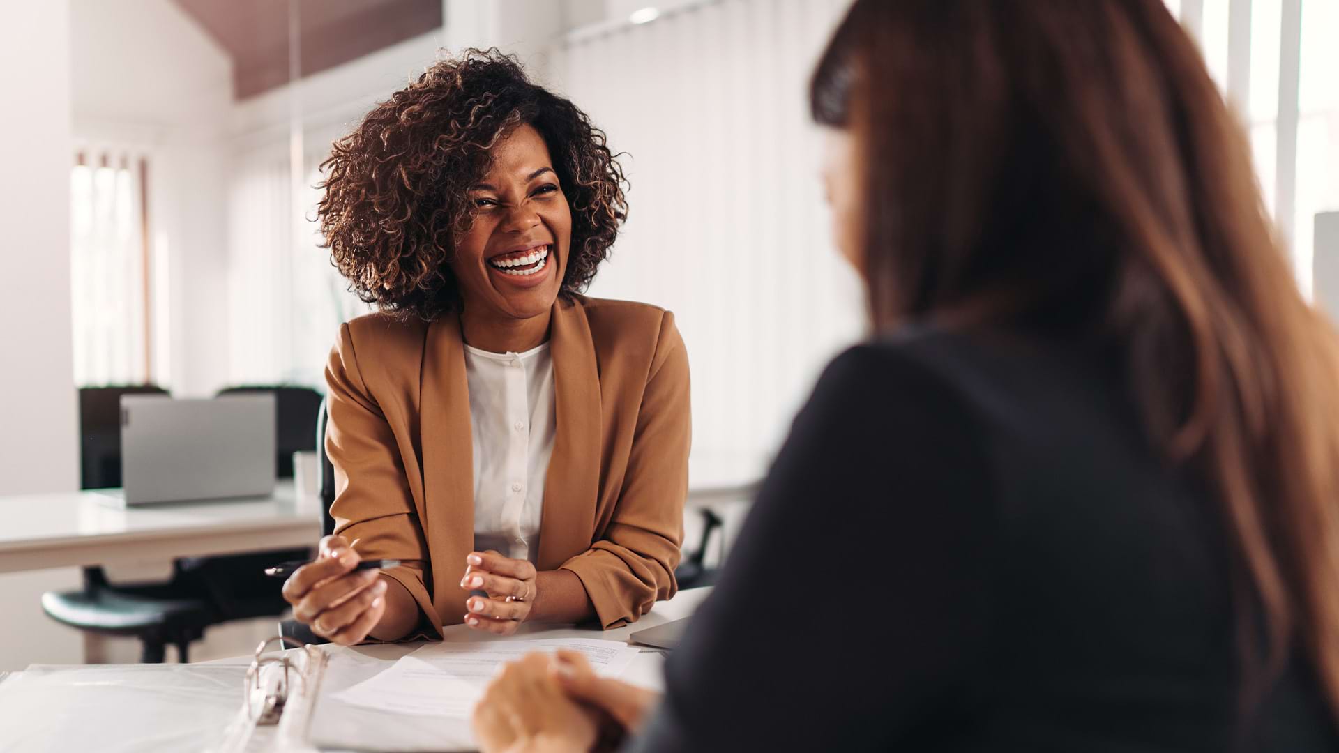 Female financial advisor consulting a client at the meeting and having a business conversation.